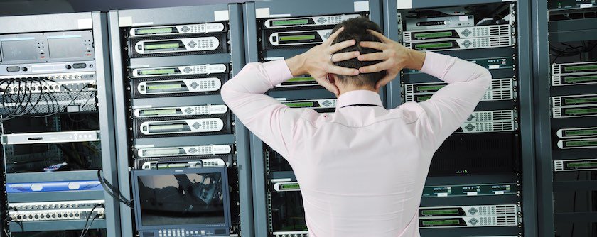 man standing in front of a rack of servers in a cloud data center